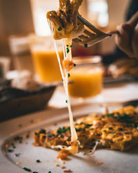 Close-up of hand pouring food in plate