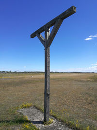 Windmill on field against blue sky