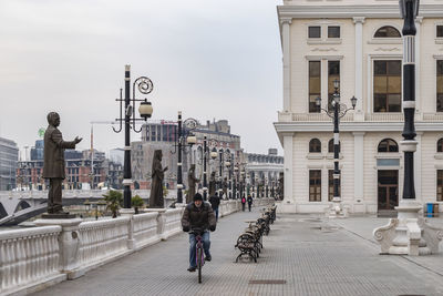 People walking on street amidst buildings in city