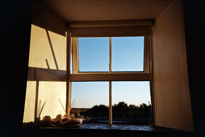 Sea seen through glass window against clear sky