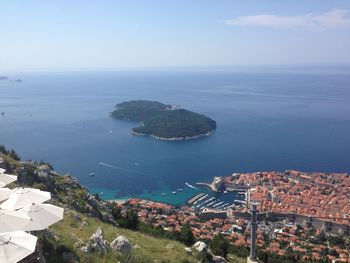 Town by seascape against sky