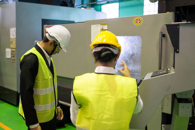 Rear view of man standing in factory