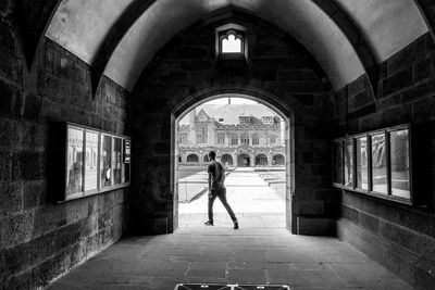 Woman standing at entrance of historic building