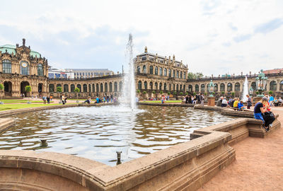 People at fountain in front of building