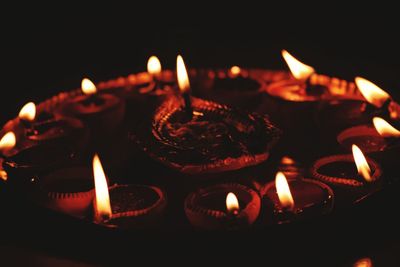 Close-up of lit candle in dark room