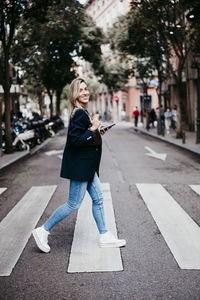 Full length of woman on road in city