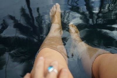 Midsection of woman relaxing in swimming pool