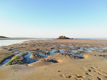 Scenic view of beach against clear sky