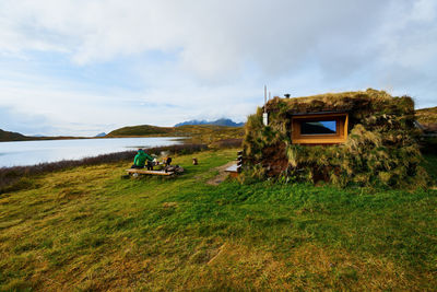 Wooden hiking cabin covered with grass and hiker on lofoten islands in norway