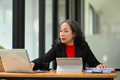 Young businesswoman using laptop at office