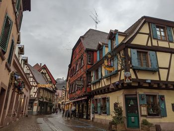 Half-timbered buildings and castle on a mountain in the background in ribeauville, france.