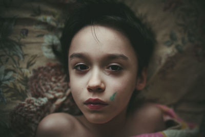 Close-up portrait of cute boy lying on bed