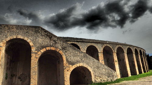 Low angle view of old building against cloudy sky