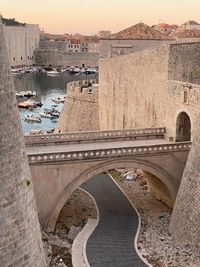 High angle view of arch bridge over canal against buildings in city