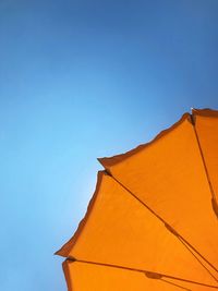 Low angle view of orange parasol against sky