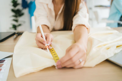 Midsection of doctor writing on book