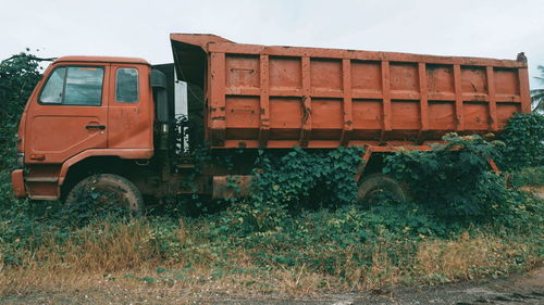 Abandoned truck on field against sky