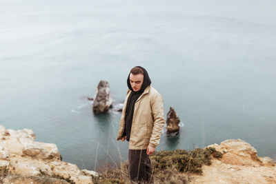 Young woman standing against sea
