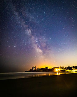 Milky way galaxy and stars in the night sky above beach houses.