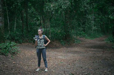 Full length portrait of teenage girl standing in forest