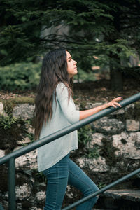 Girl walking on staircase against plants