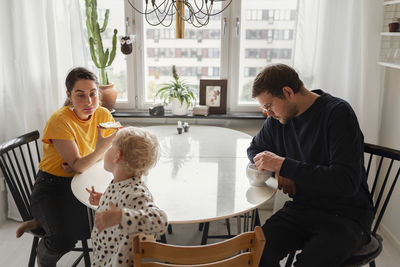 Full length of father with daughter sitting at home