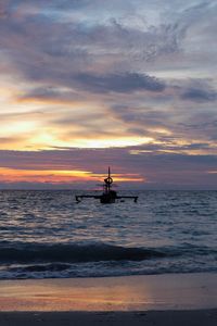 Silhouette boat sailing in sea against sky during sunset