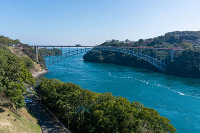 Scenic view of bridge over river against clear blue sky