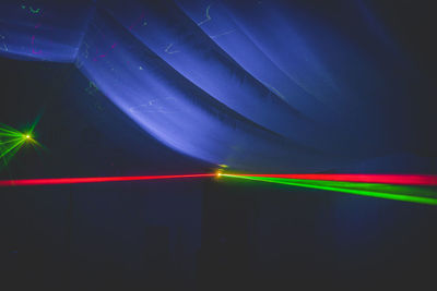 Light trails against blue sky at night