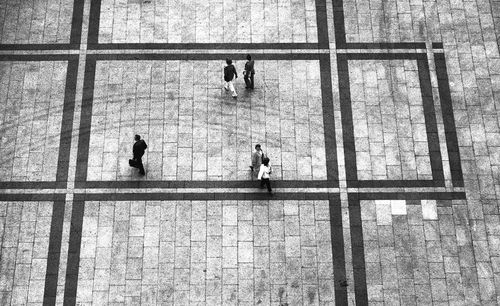 High angle view of people walking on tiled floor 