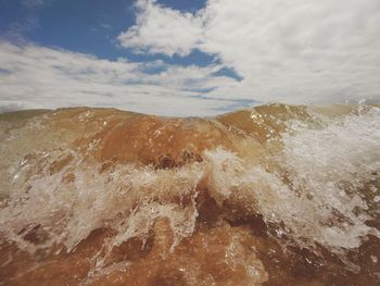 Waves splashing in sea against sky