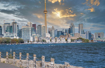 Modern buildings in city against cloudy sky