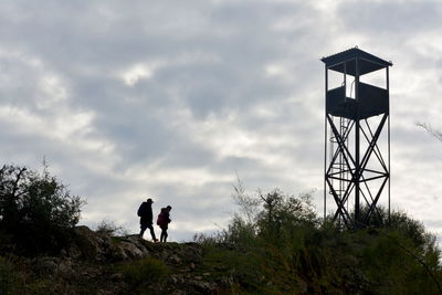 Man and tower against sky