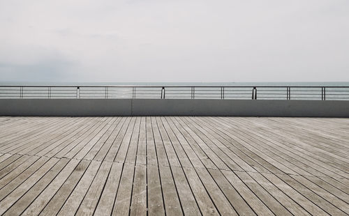 Surface level of pier on sea against clear sky