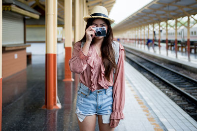 Woman standing at railroad station