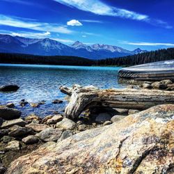 Scenic view of lake by mountains against sky