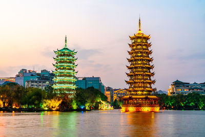 Illuminated buildings in city against sky