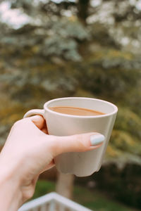 Close-up of woman hand holding coffee cup