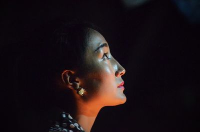 Close-up of man using mobile phone against black background