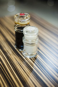 High angle view of soy sauce with pepper shaker on table
