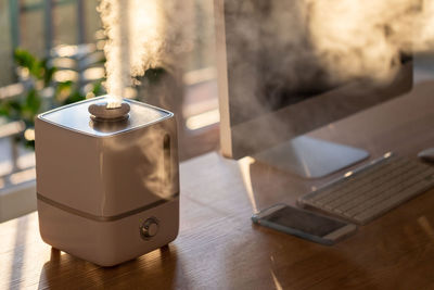 Close up of air humdifier with steam on the table at home