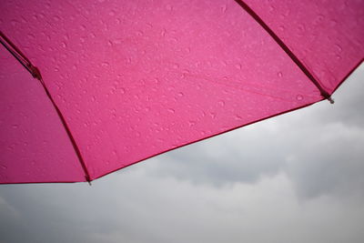 Pink umbrella against sky during rainy season