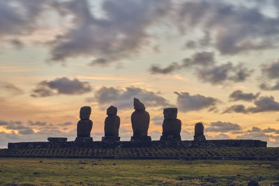 Ancient moai statues against sky during sunset on easter island