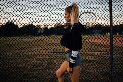 Woman looking through chainlink fence