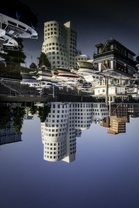 Reflection of buildings in canal against sky