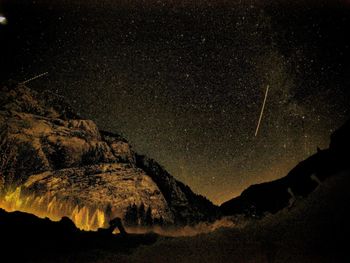 Scenic view of silhouette rock against sky at night