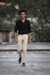 Portrait of young man standing on road