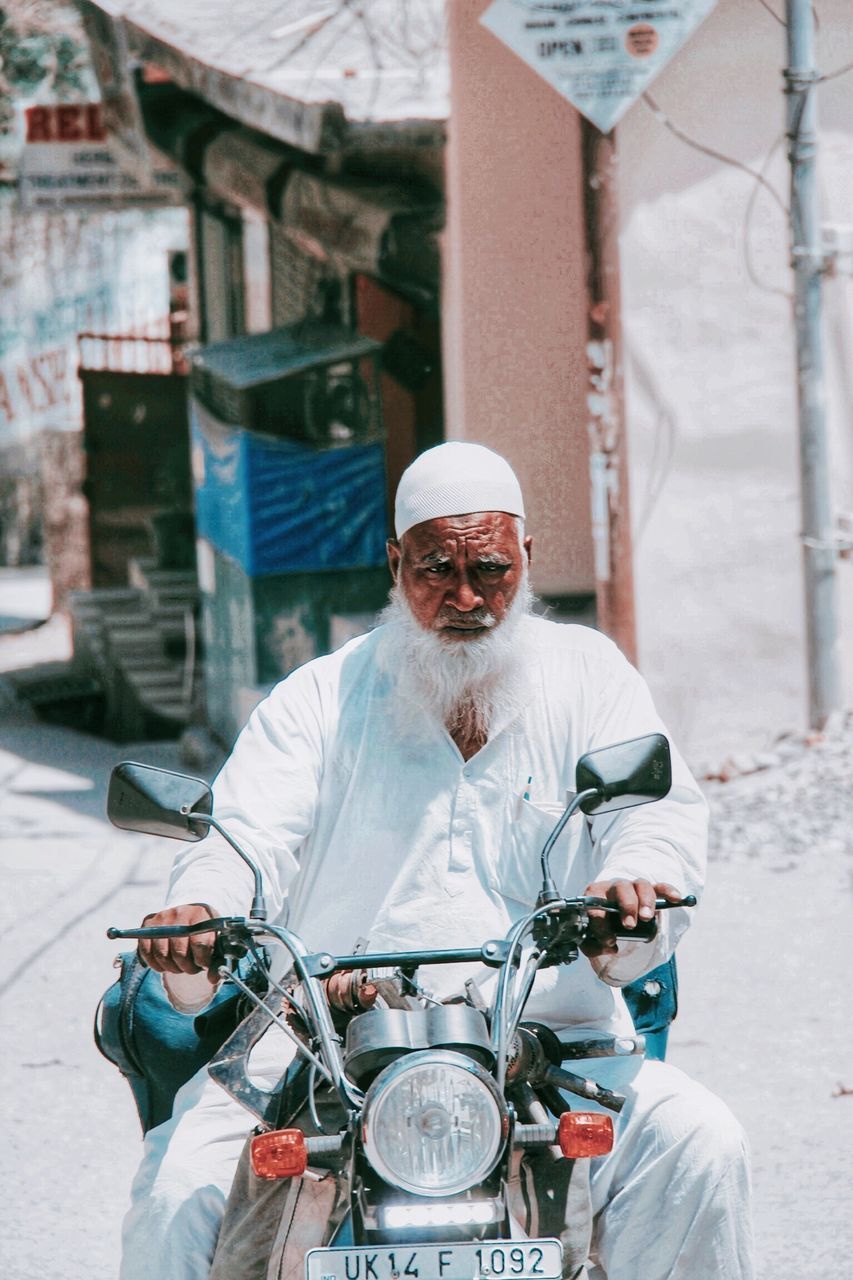 PORTRAIT OF MAN RIDING MOTORCYCLE ON STREET