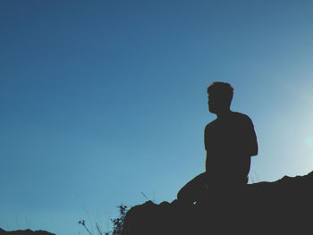 Silhouette man standing against clear blue sky