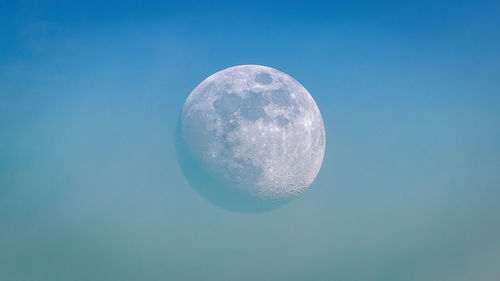 Low angle view of moon against blue sky